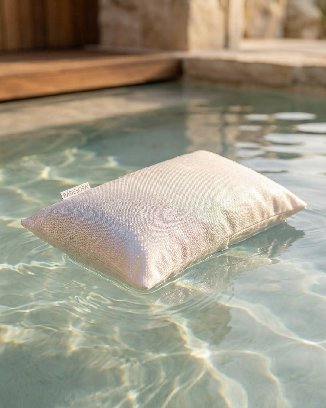 Poolsofa Relaxkissen in der Farbe Perlmutt schwimmt auf dem Wasser.