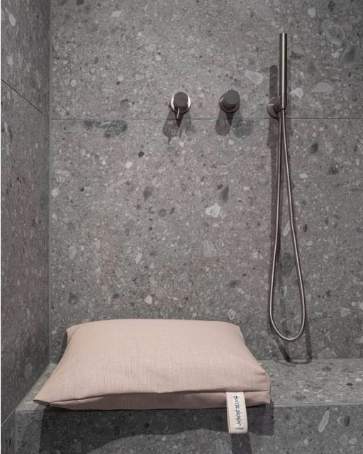 Nahaufnahme des Badesofa Sitzkissen (Farbe: Perlmutt) auf einer gemauerten Bank in der Dusche. 
