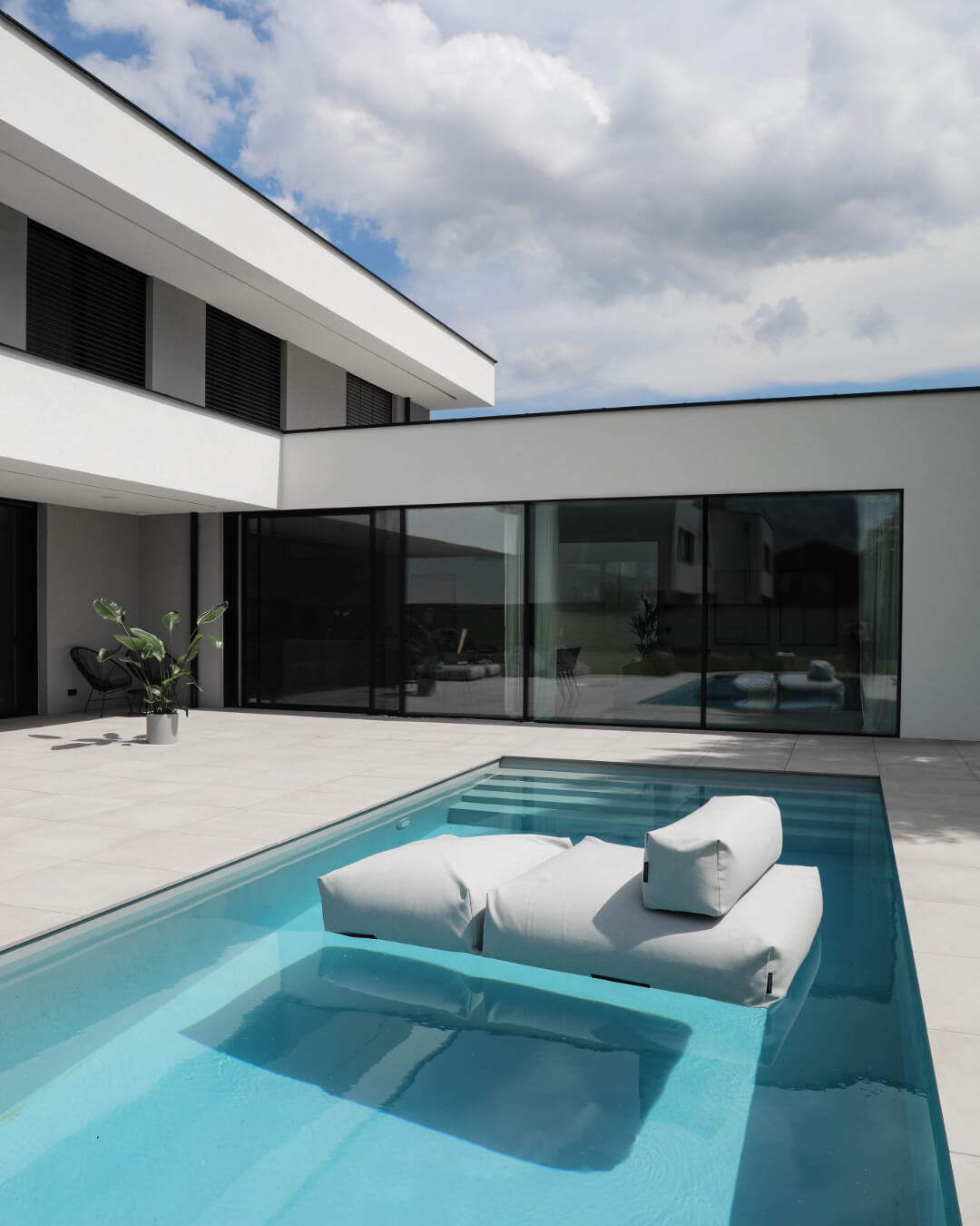 Ein Poolsofa Double in Grau schwimmt ain einem Pool. 