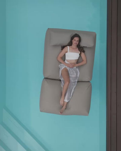 Das Video zeigt eine Frau, die auf ihrem Poolsifa auf dem Pool dahingleitet.